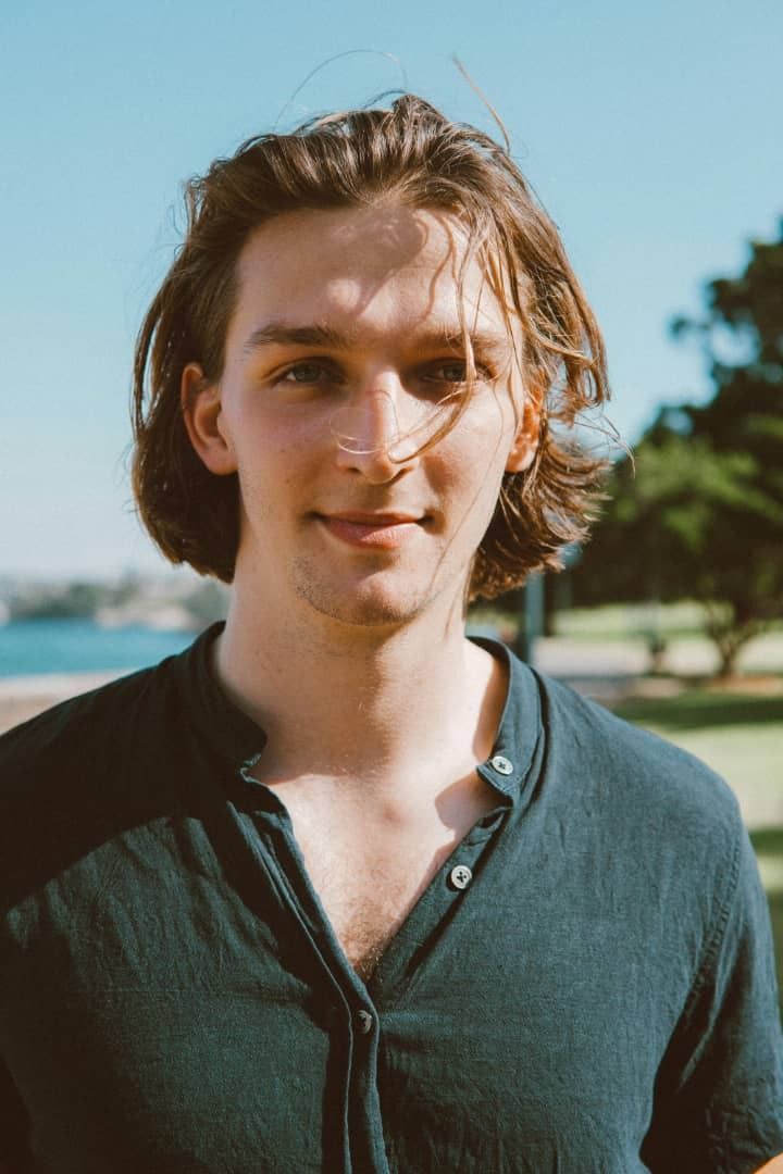 Portrait of the ChatCoffee editorial lead captured in soft daylight with a latte-toned backdrop for author bios and metadata.